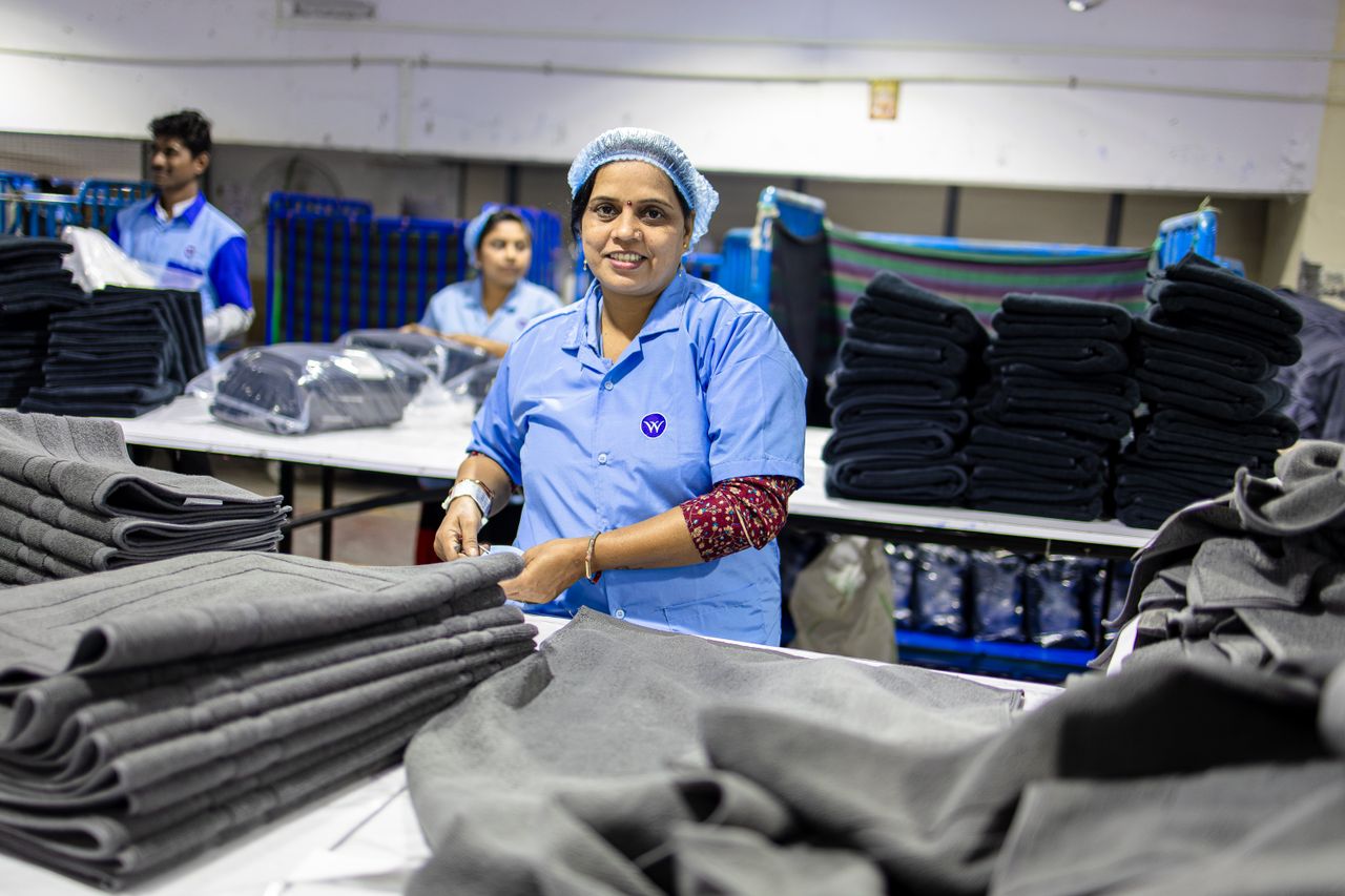 Textile factory workers folding fabrics, showcasing teamwork and industry.